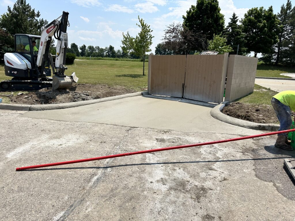 a white machine next to a concrete driveway