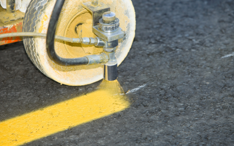 a machine with a yellow paint sprayer