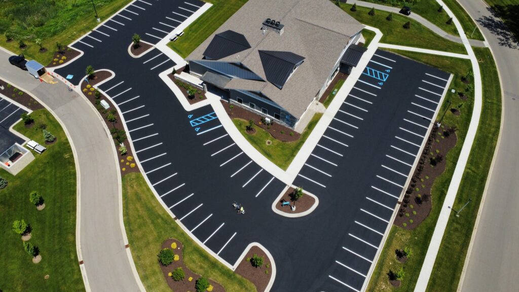 a building with parking lot and grass